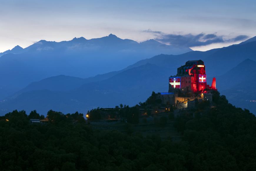 La Sacra di San Michele illuminata con il drapò del Piemonte